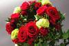 Flowers by Toi Toi Floral Boutique. Red roses in a mix of green foliage come together in this floral Christmas wreath.